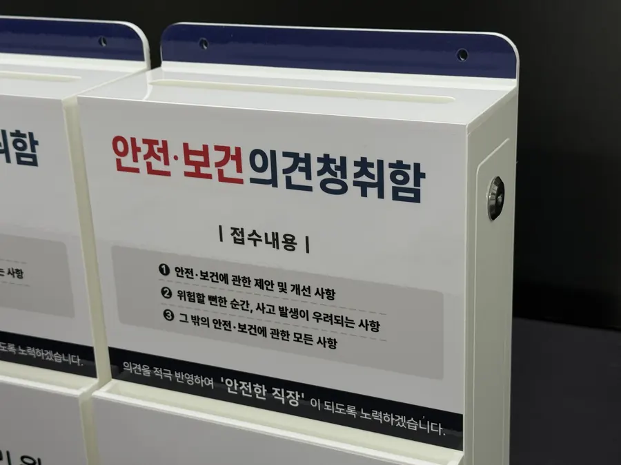 화이트 바탕에 네이비 포인트 띠를 넣고 측면에 잠금장치를 단 안전보건 의견청취함