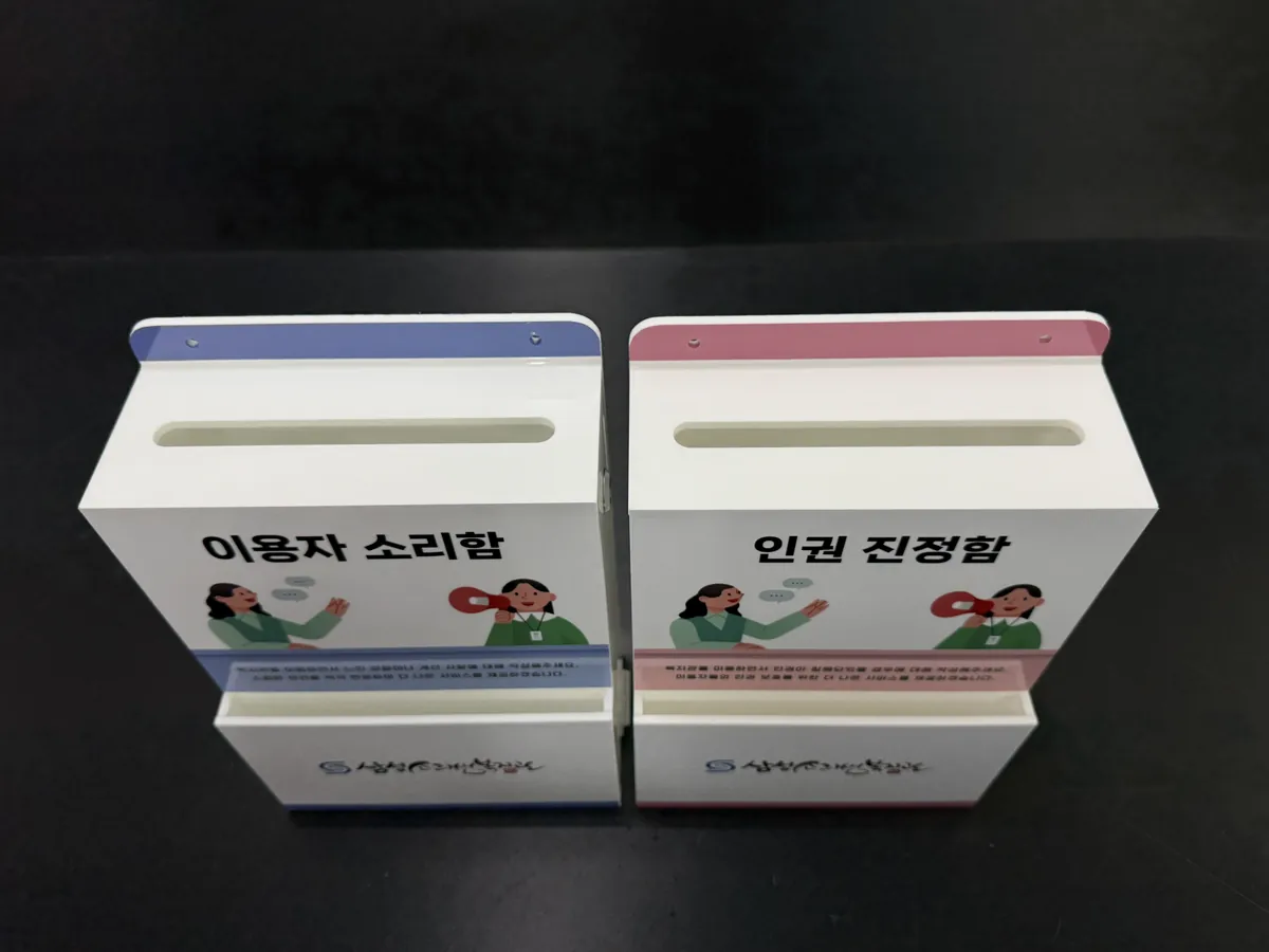 상단 라운드 투입구와 블루 핑크 띠가 보이는 삼성소리샘복지관 소리함, 진정함 상단 뷰